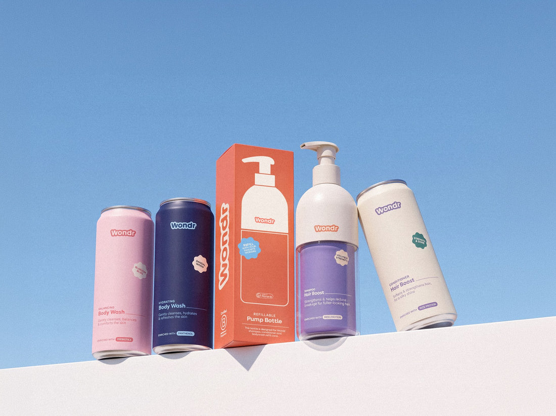 WONDR Liquids bottles and cans on a white ledge against a blue sky